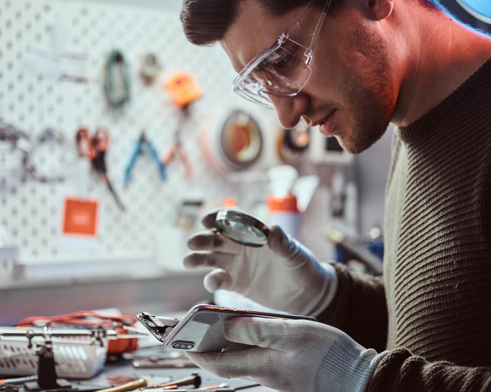 electronic technician repair damaged smartphone in the workshop.jpg